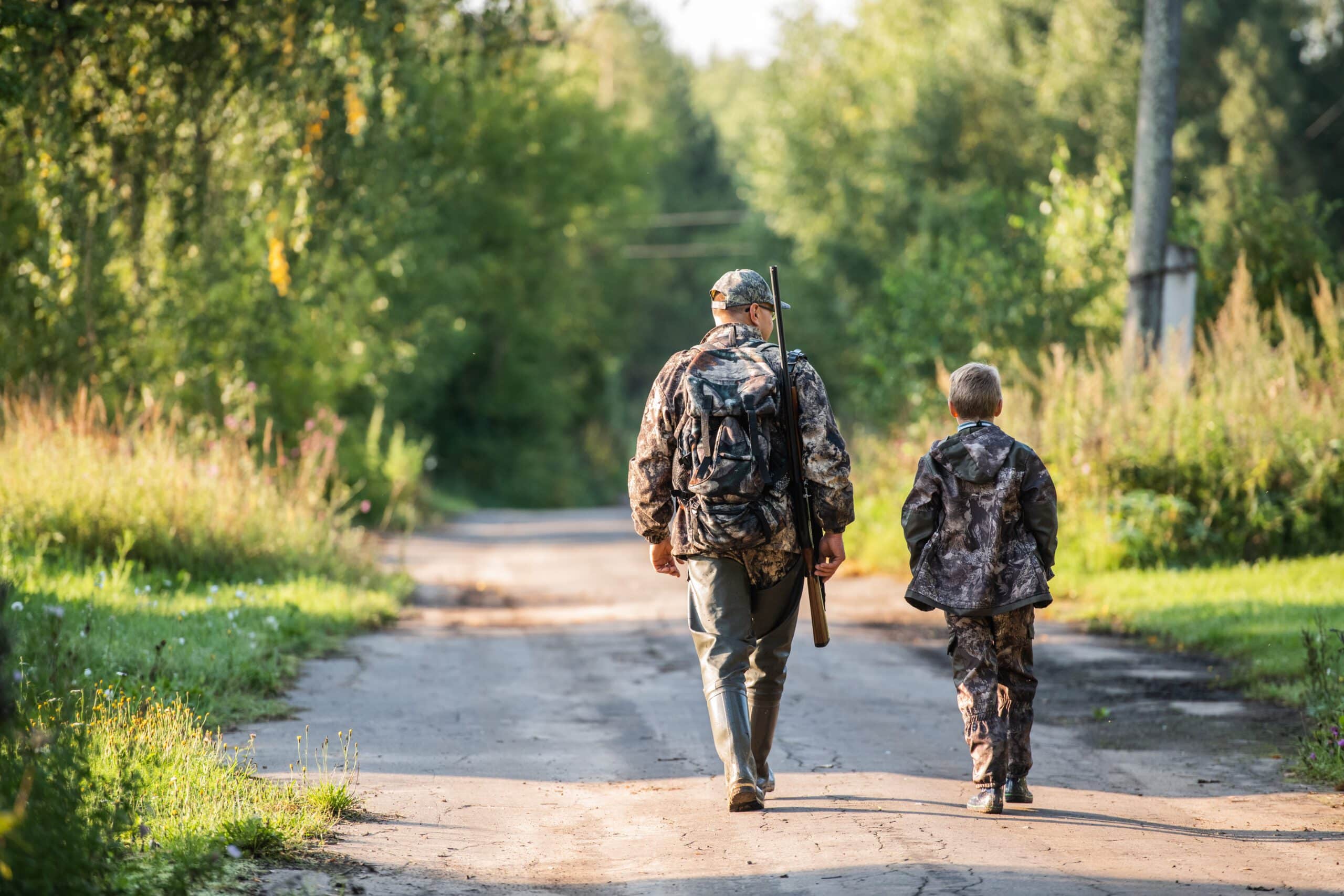father pointing and guiding son on first deer hunt.